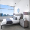 Modern bedroom with large windows and city view at Ashton Austin apartments for rent in downtown Austin	